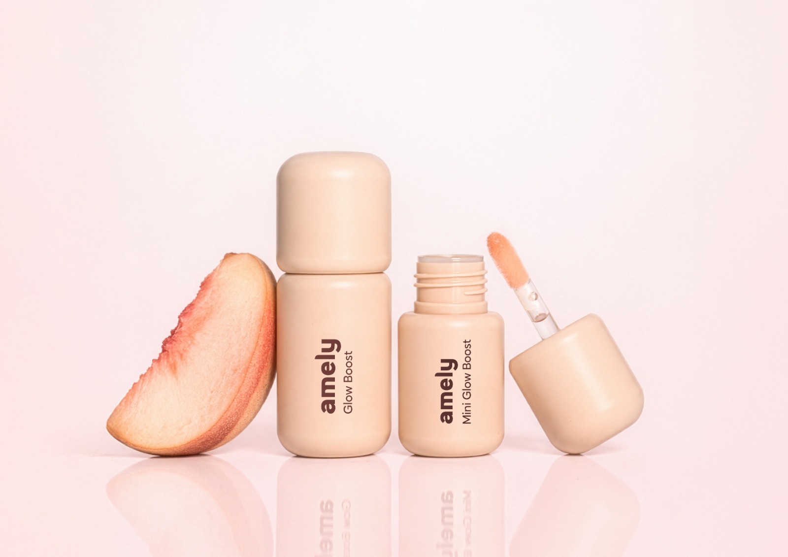 Produsele AMELY — Glow Boost și Mini Glow Boost alături de o felie de piersică